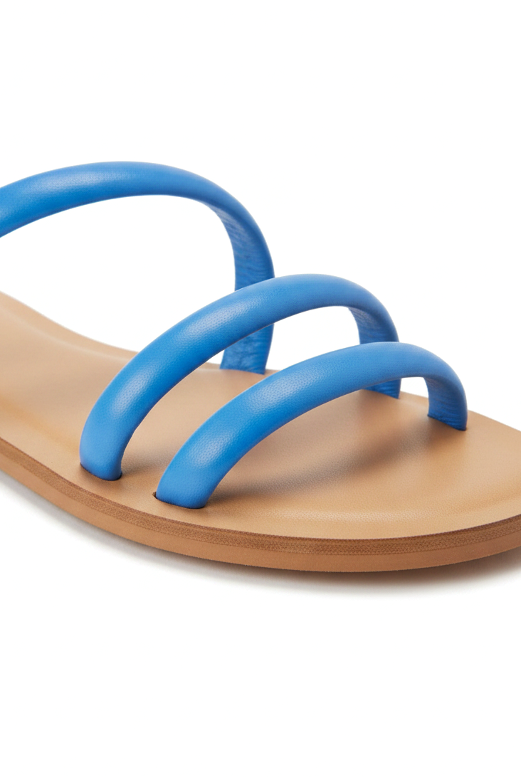 Close-up of the rounded tubular leather straps and natural leather footbed on the Mangará Cacau blue slide