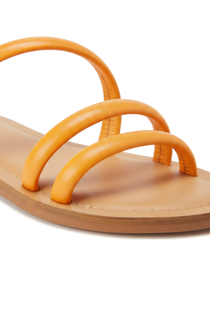 Close-up of the rounded tubular leather straps and natural leather footbed on the Mangará Cacau orange slide