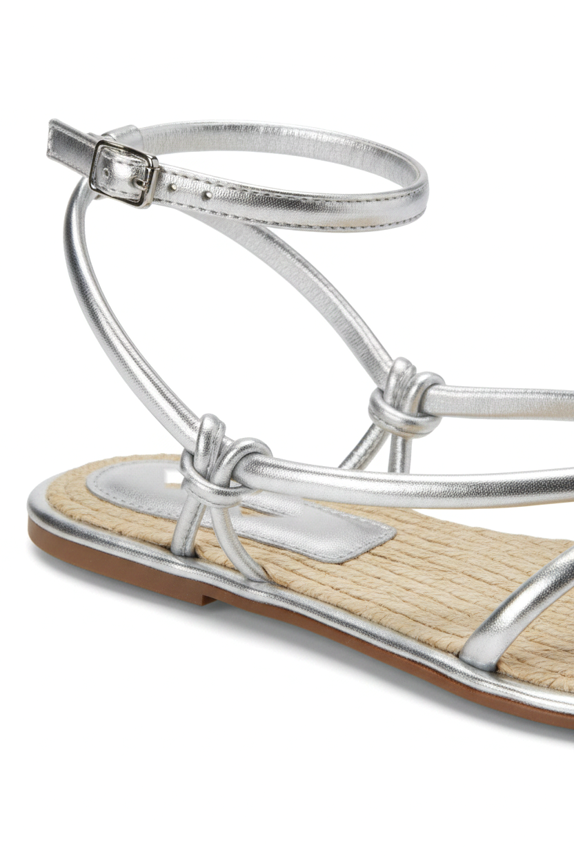 Close-up of the knotted straps, buckle and woven raffia footbed on the Mangará Angico silver sandal