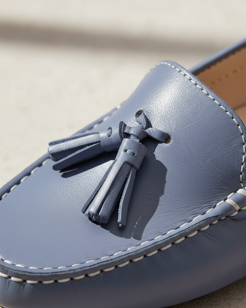 Nahaufnahme des Quastenknotendetails auf den blauen Leder-Slippern von Caviuna