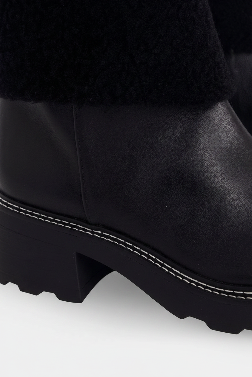 Close up detail of the white contrast stitching along the welt of the Andira black leather boots