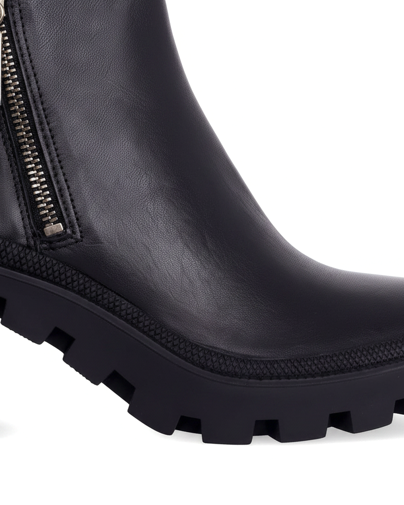 Close up of the silver side zip, textured rubber welt and deep lug sole on Sophora black ankle boots