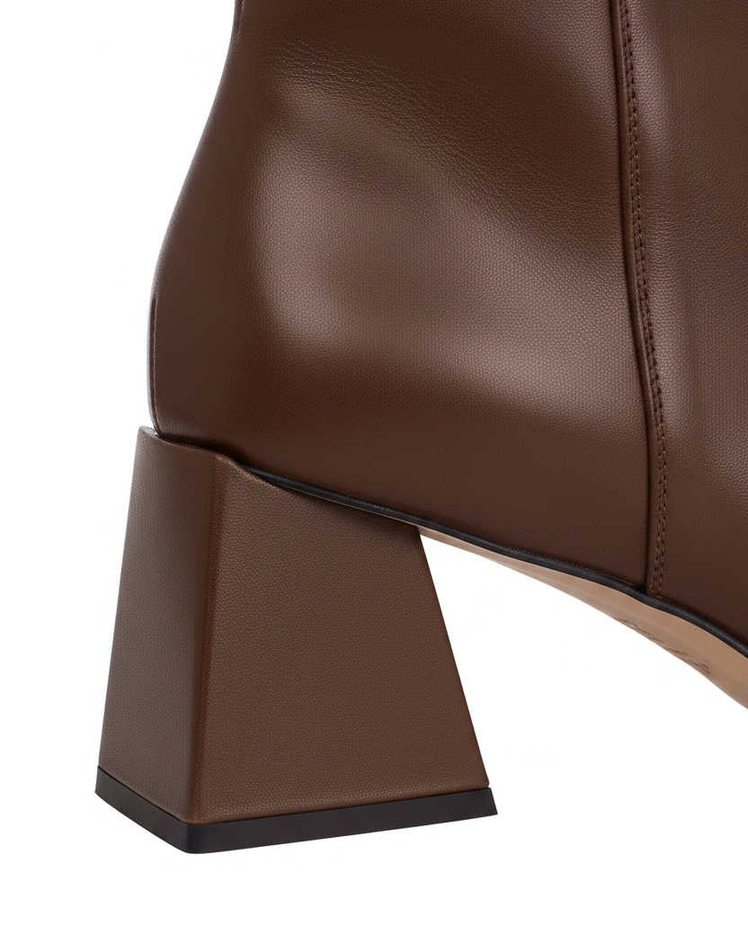 Close up of the flared trapeze block heel on Mabea brown leather ankle boots