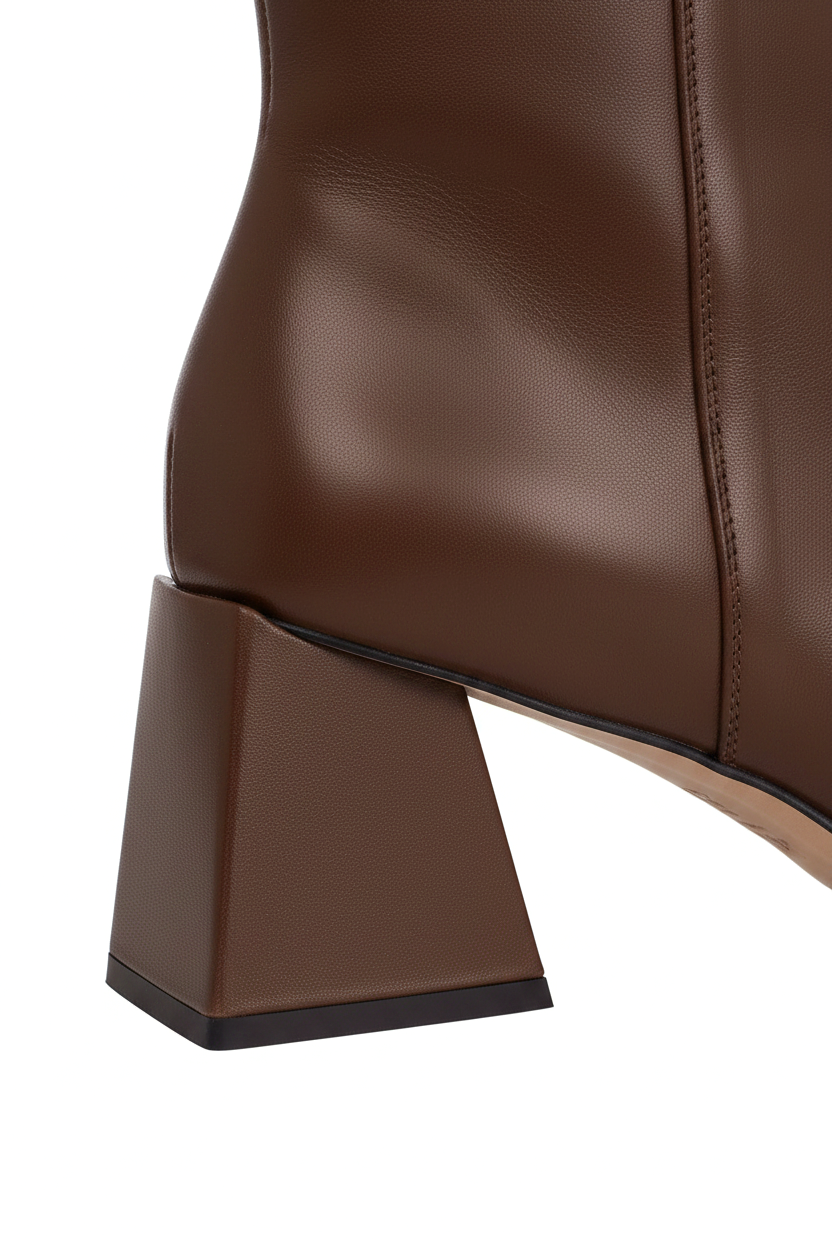 Close up of the flared trapeze block heel on Mabea brown leather ankle boots