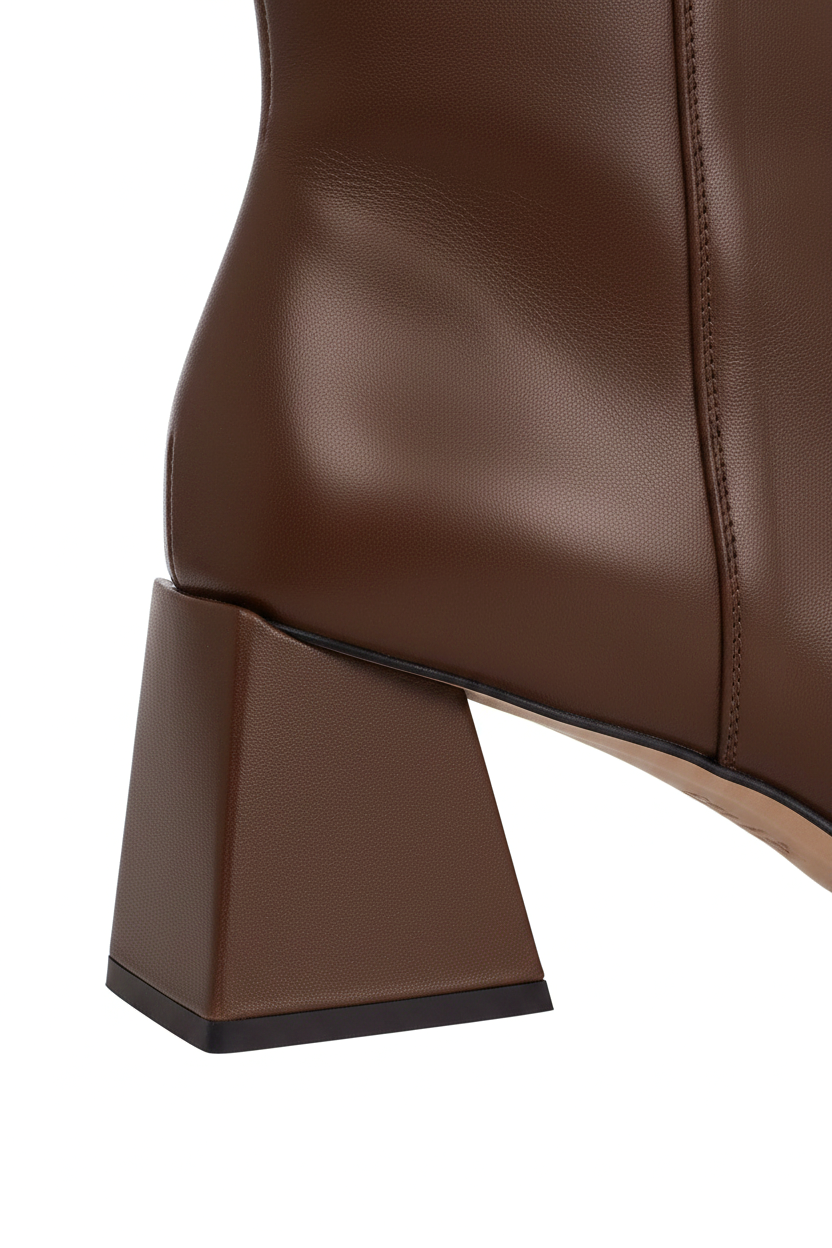 Close up of the flared trapeze block heel on Mabea brown leather ankle boots