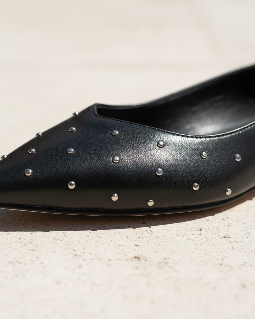 Nahaufnahme des Ballerinas Hamelia aus schwarzem Leder mit verstreuten silbernen Nieten