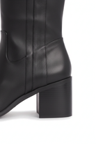 Close up detail of the squared block heel and V shaped ankle panel of the Canna black leather boots