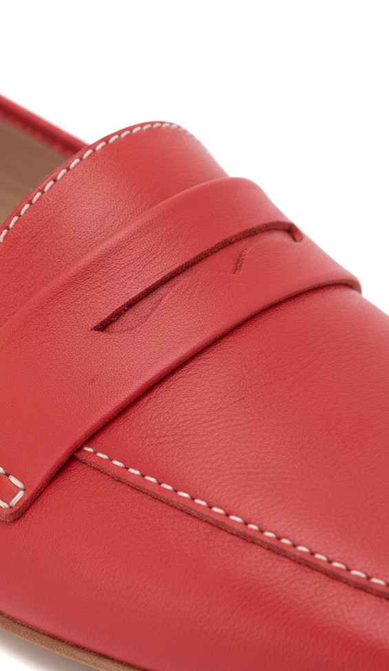 Macro detail of Mangará Cipó red leather loafers: penny strap with wavy slot and white contrast topstitching – SKU 201NVCE