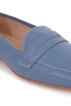 Close-up detail of Mangará Cipó blue leather loafers: white contrast stitching, wavy penny slot and natural sole edge – SKU 201NVMA