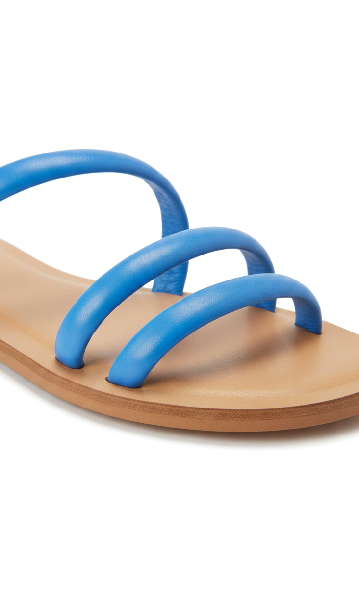 Close-up of the rounded tubular leather straps and natural leather footbed on the Mangará Cacau blue slide