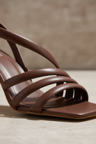 Close-up of the crisscrossing strap detail on Cedro chocolat calf leather sandals