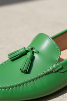 Close-up of the tassel knot detail on Caviuna green leather loafers