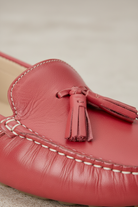 Close-up of the tassel knot detail on Caviuna pink leather loafers