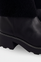 Close up detail of the white contrast stitching along the welt of the Andira black leather boots