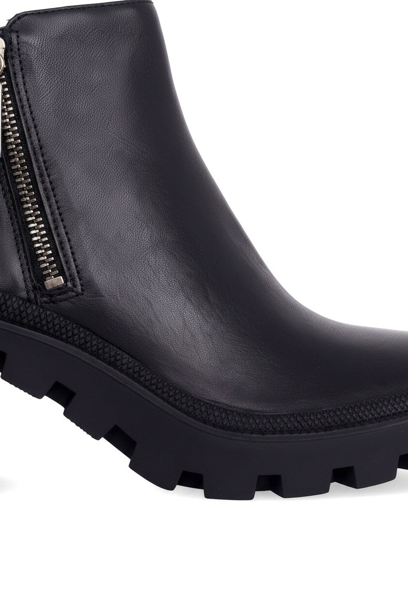 Close up of the silver side zip, textured rubber welt and deep lug sole on Sophora black ankle boots