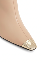 Close up detail of the polished gold metal toe cap on the Inga beige leather boots