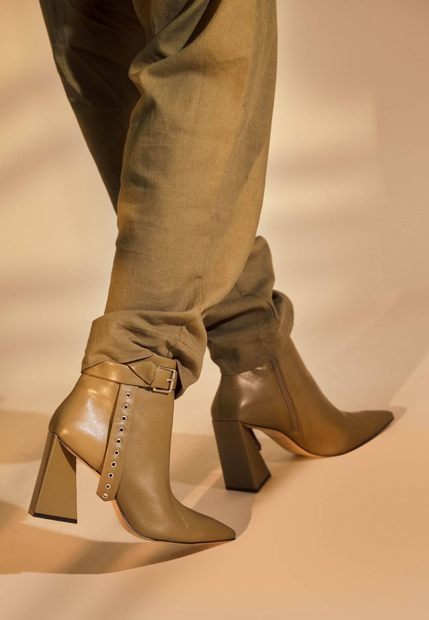 Close view of the silver buckle and eyelet strap on Salvia olive green ankle boots, worn